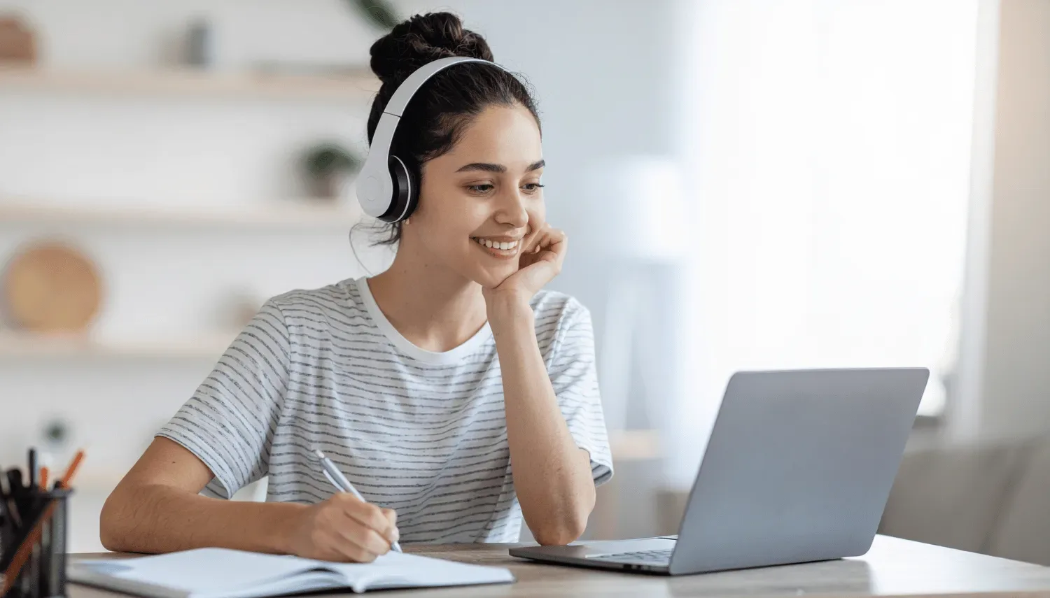 A student learning online with headphones and notes